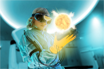Boy in virtual reality headset interacting with digital floating sun