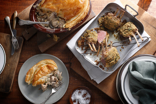 Bistro table with herb crusted lamb racks and rustic chicken pie