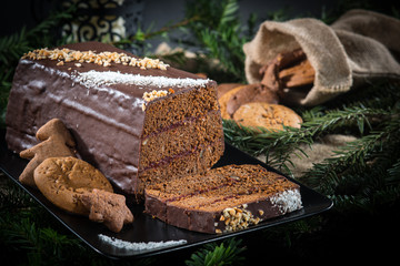 Cookies with cake on a black background with Christmas tree.