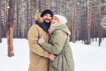 Dreamy woman looking at the sky in the embrace of husband