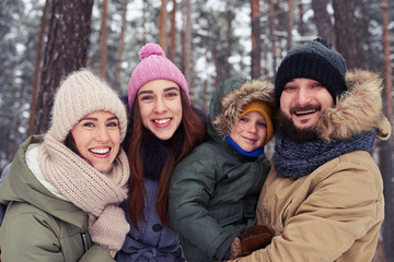 Funny family of 4 members smiling and laughing during the winter