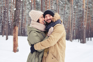 Obraz premium Romantic couple embracing in a snowy forest