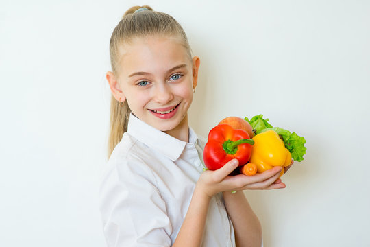 Happy fitness girl holding vegetables isolated