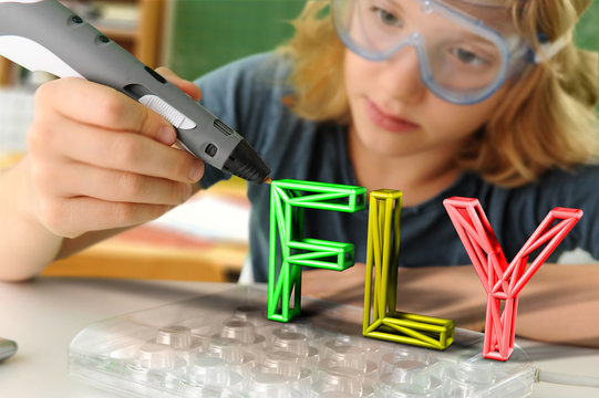 Boy with digital pen and 3D model of capital-lettered word in classroom