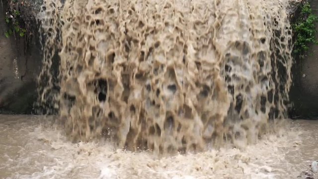 Dirty wastewater urban channel. Mud flow of water after rain. City sewer system