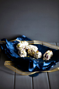 Dried fruit nougat in blue christmas wrapping paper on cake stand
