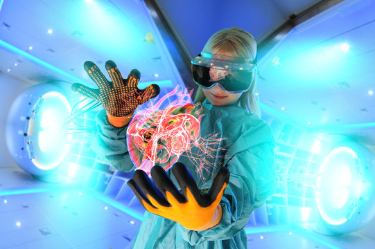Girl in virtual reality headset interacting with digital floating human heart