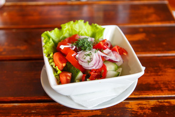 Salad of cucumbers, tomatoes and red onion is in the plate