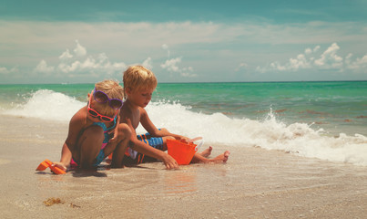 kids play with sand on summer beach