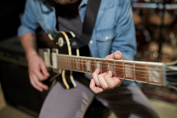 Fototapeta na wymiar man playing guitar at studio rehearsal