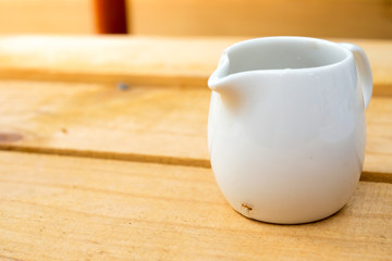 Syrup cup for coffee on the wooden table with small ant stick on it (sunlight)