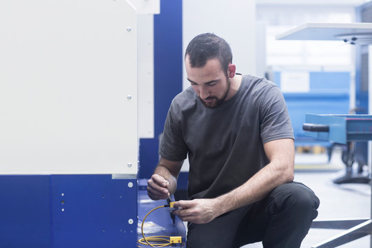 Engineer using allen key in engineering plant