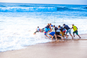 Jetski fishermen launch a personal watercraft into the sea at Ballito for a day of fishing. South Africa.