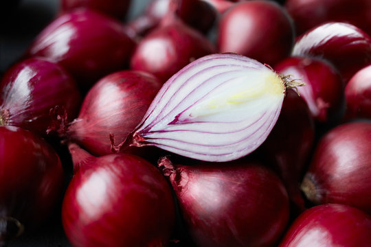 Fresh whole red onions and one halved on table