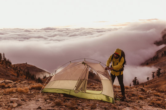 Male hiker putting up tent above the clouds, Mineral King, Sequoia National Park, California, USA