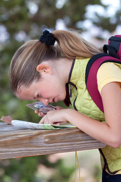 Girl peering at map with magnifier, Sedona, Arizona, USA