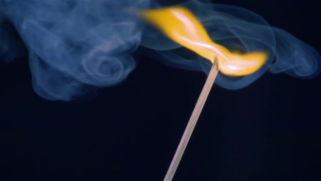 Burning match on a black background in slow motion