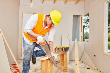 Zimmermann sägt Holz mit Handsäge