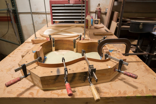 Guitar clamped in mould in workshop