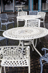 Empty metal tables and chairs in a street cafe in the fall.