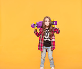 little girl in casual hipster clothes isolated over yellow background