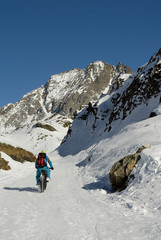 Fototapeta na wymiar bicicletta elettrica - fat bike da neve, che sale in alta montagna, Riale, Val Formazza, Ossola, Alpi Italia