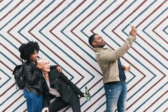 Friends taking selfie in front of zig zag pattern wall