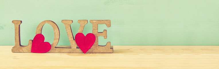 Word LOVE from wooden letters and red hearts
