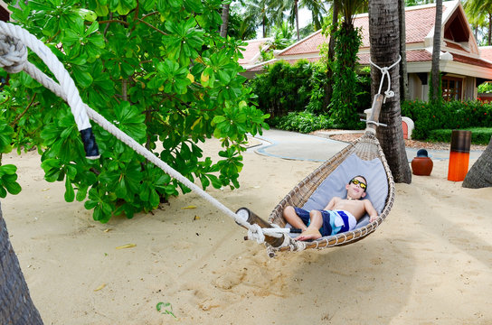 Boy enjoying a hammoc on beautiful tropical beach