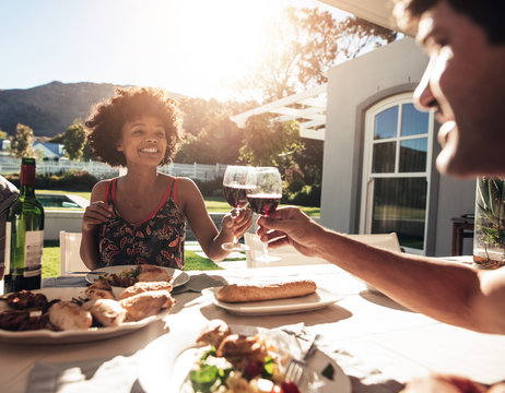 Friends toasting drinks outside during a party