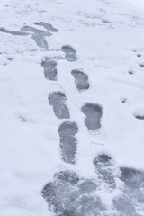 Fußspuren auf zugeschneiter Eisschicht