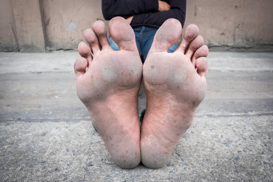 Dirty foot of a man sitting on old concrete floor.