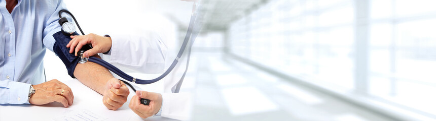 Doctor measuring patient blood pressure.