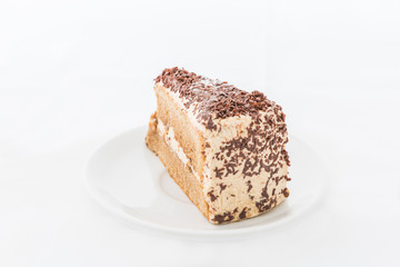 Chocolate cake slice with curl on white dish