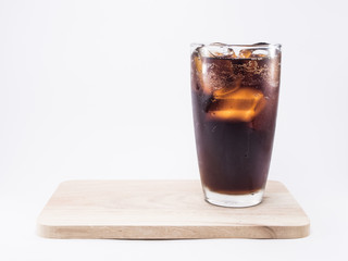 soft drink is cool with ice cubes in full glass on wood squares