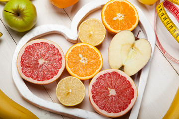 Fruits in heart and centimeter on a white background