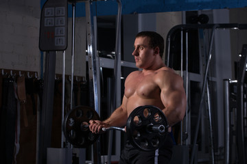 Fototapeta na wymiar beautiful, powerful, strong man posing at the gym