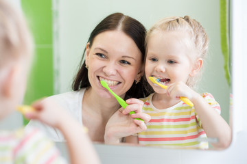 Mother And Child Daughter Brushing Teeth Together
