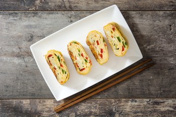 Traditional tamagoyaki Japanese omelette on wooden background