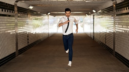 Young man running through underpass