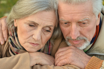 Sad senior couple in  park