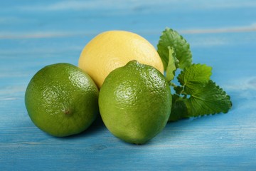 limes and lemon on a wooden background