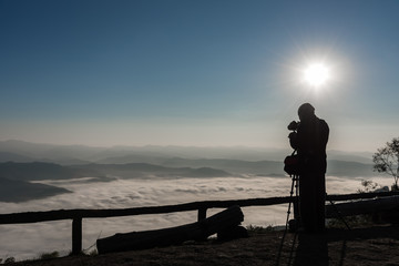 Silhouette of photographer taking photos on the mountains. Filter effect style