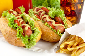 Hotdogs on plate with cola on white background