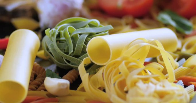 Dolly close up push in view of different variety of Italian pasta and ingredients