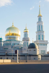Fototapeta na wymiar mosque with gold domes against the blue sky