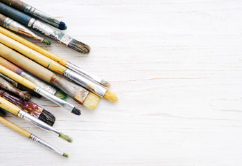 Аrtist paint brushes closeup on a white wooden background.   