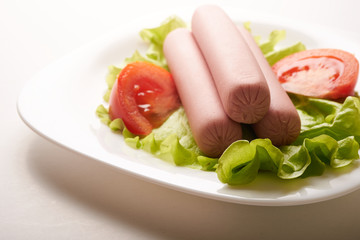 sausages with vegetables on a white background