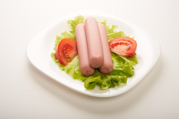 sausages with vegetables on a white background