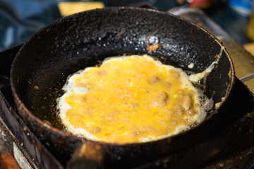 Scrambled egg with meat on frying pan